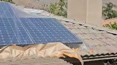 Careful masking around rooftop solar panels before exterior painting