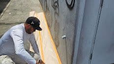 Painter applying crisp trim lines on a stucco exterior